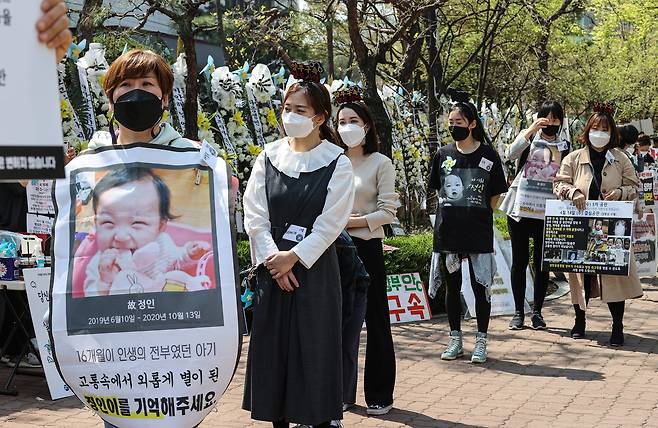 16개월 된 입양 딸 정인 양을 학대해 숨지게 한 혐의를 받는 양부모의 5차 공판이 열린 7일 서울 양천구 서울남부지방법원 입구에서 대한아동학대방지협회 회원들을 비롯한 시민들이 양부모의 강력한 처벌을 촉구하는 팻말을 들고 있다. [연합뉴스]