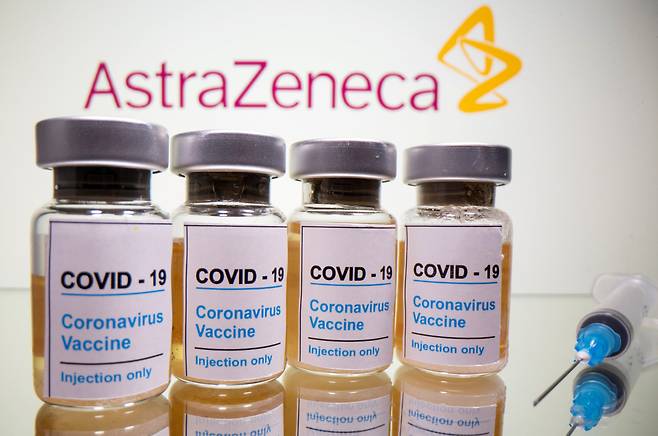 Vials with a sticker reading, "COVID-19 / Coronavirus vaccine / Injection only" and a medical syringe are seen in front of a displayed AstraZeneca logo in this illustration taken October 31, 2020. (Yonhap-Reuters)