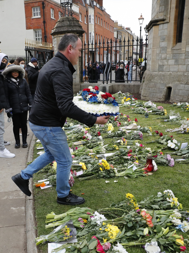 한 영국인이 윈저성 입구에 꽃다발을 갖다놓으며 필립공을 추모하고 있다. /AP연합뉴스