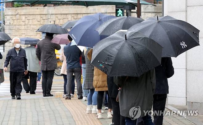 비가 와도 계속되는 검사행렬 (서울=연합뉴스) 김도훈 기자 = 12일 오후 서울 중랑구 보건소에 마련된 코로나19 임시선별진료소를 찾은 시민들이 우산을 쓰고 순서를 기다리고 있다. superdoo82@yna.co.kr