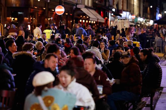영국 런던 시민들이 12일(현지시간) 소호거리의 야외 식당에서 음식을 먹고 술을 마시고 있다. 영국은 이날부터 코로나 19 방역을 위한 봉쇄조치를 완화해 야외 업소들이 일제히 영업을 재개했다. AFP=연합뉴스