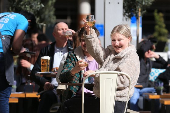 한 영국인이 영국 리즈의 펍에서 12일 기뻐하며 맥주 잔을 높이 들어보이고 있다. [AFP=연합뉴스]