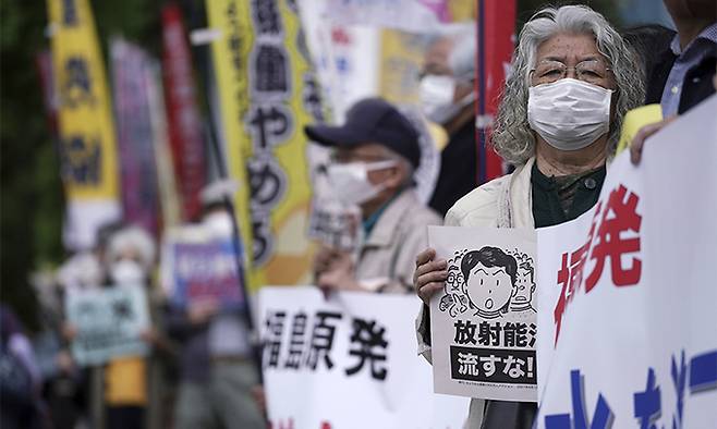 13일 일본 도쿄 총리관저 앞에서 시민들이 플래카드를 들고 정부의 후쿠시마 원전 오염수 해양 방류 결정에 대한 반대 시위를 벌이고 있다. 도쿄=AP연합뉴스
