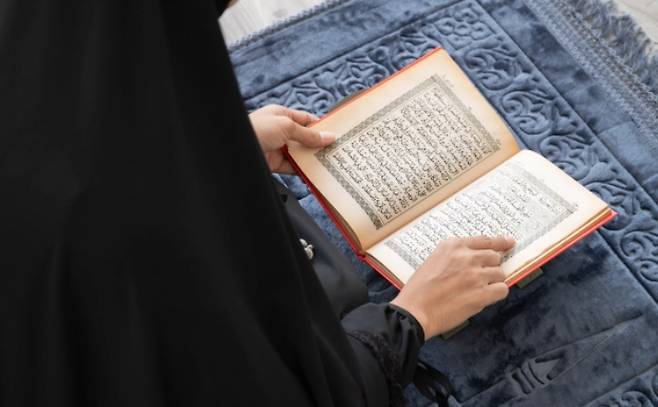 이슬람경전(코란)을 읽고 있는 여성 자료사진.