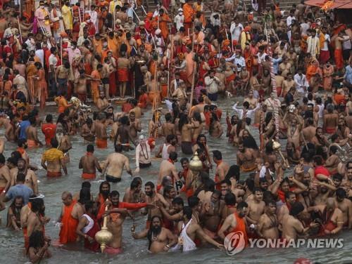 12일 인도 하리드와르의 갠지스강변에서 진행된 쿰브멜라 축제.참가가 대부분은 노마스크 상태로 물에 들어가 축제를 즐겼다. AP=연합뉴스