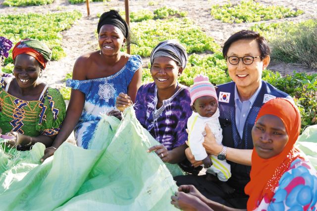 김광동 더멋진세상 대표가 2015년 세네갈의 본나바 마을에서 아기를 안고 주민들과 인사하고 있다.