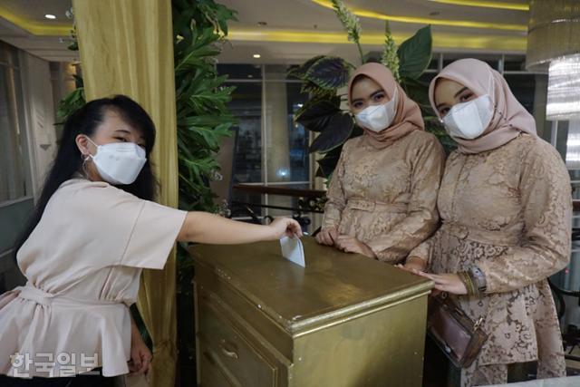 친구 결혼식에 온 인도네시아 여성이 축의금을 상자에 넣고 있다. 데폭=고찬유 특파원