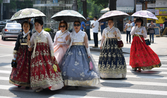 자외선 주의보가 내려진 29일 서울 광화문을 찾은 시민들이 한복을 입은채 우산을 들고 거리를 걷고 있다. 박지환 기자 popocar@seoul.co.kr