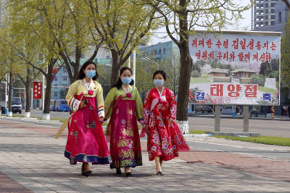 한복을 입은 북한 여성들이 15일 고 김일성 주석의 생일(태양절)을 맞아 평양의 개선문 주변을 걷고 있다.AP 연합뉴스