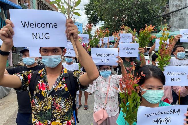 미얀마 양곤에서 17일 시민들이 민주진영통합세력인 ‘국민통합정부(NUG)’를 환영한다는 손팻말을 들고 거리행진을 하고 있다. 양곤|로이터연합뉴스