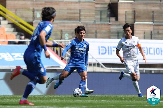 Nineteen-year-old Jeong Sang-Bin of the Suwon Bluewings, center, dribbles the ball in a game against Ulsan Hyundai FC at Suwon World Cup Stadium in Suwon, Gyeonggi on Sunday. [YONHAP]