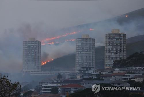 19일(현지시간) 테이블마운틴 산불이 강풍에 케이프타운 시내 근처로 번지고 있다. [로이터=연합뉴스]