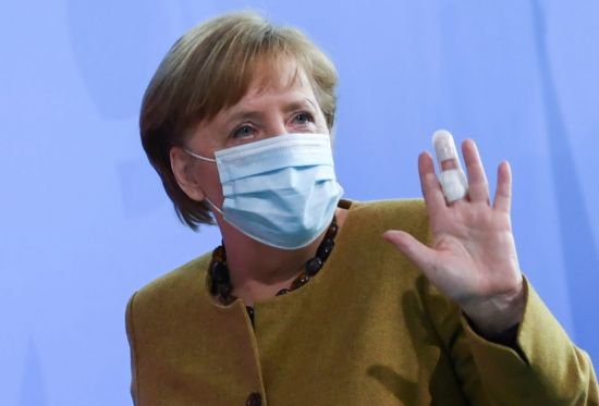 앙겔라 메르켈 독일 총리가 13일(현지시간) 베를린에서 각의를 주재한 뒤 브리핑을 마치면서 밴드를 붙인 손을 들어 보이고 있다. [이미지출처=연합뉴스]