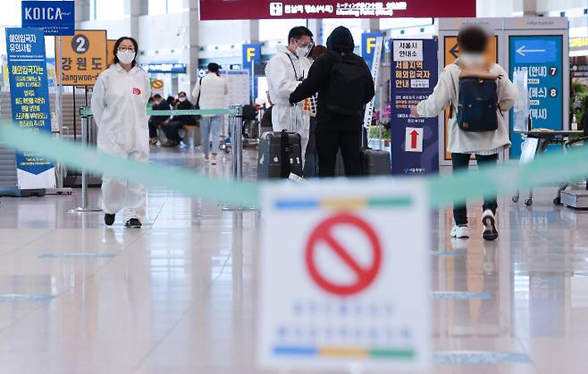 20일 인천국제공항 제1여객터미널 입국장에서 해외 입국자들이 방역절차에 따라 이동하고 있다. 연합뉴스