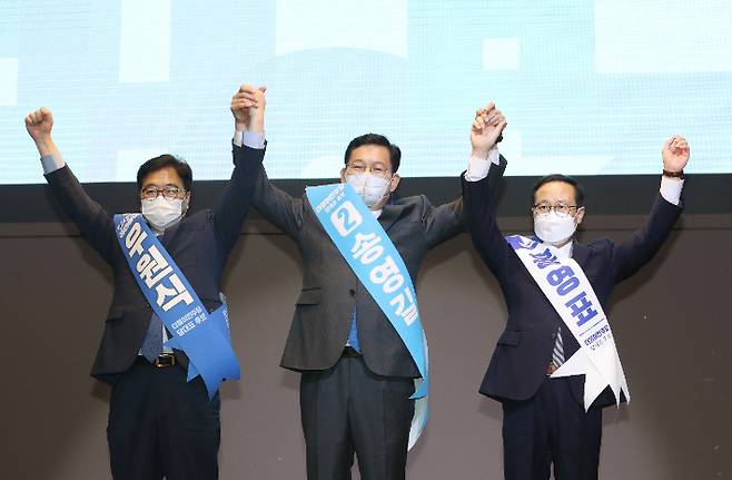 20일 오후 전북 전주시 완산구 그랜드힐스턴 호텔에서 열린 더불어민주당 당대표·최고위원 후보 합동연설회에서 당대표 후보들이 손을 맞잡고 있다. 왼쪽부터 우원식, 송영길, 홍영표 후보. 민주당 전북도당 제공