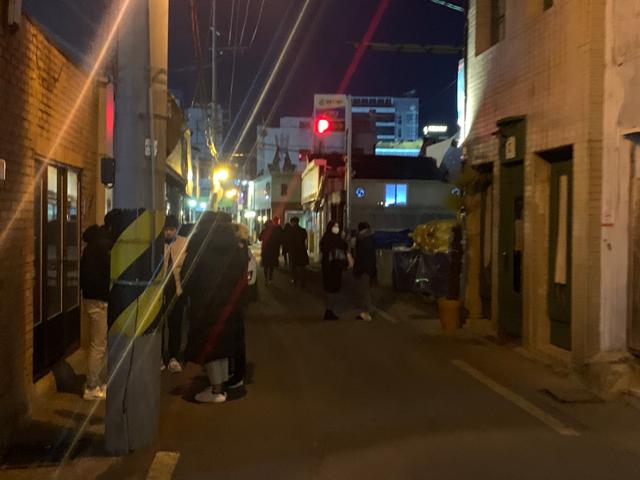 코로나 확산으로 가게들이 영업제한 시간인 10시에 문을 닫자 시민들이 길거리에서 담배 연기를 내뿜고 있다. 한국일보 자료사진