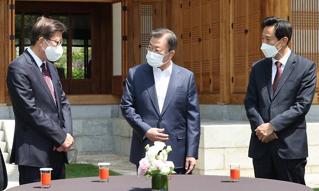President Moon Jae-in greets Seoul Mayor Oh Se-hoon (right) and Busan Mayor Park Heong-joon (left) at the Sangchunjae guesthouse of the presidential compound on Wednesday, prior to their luncheon meeting. (Yonhap)