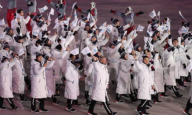 지난 2018년 2월 9일 강원도 평창 올림픽스타디움에서 열린 2018 평창동계올림픽 개막식에서 남북 선수단 공동기수인 남측 원윤종, 북측 황충금이 한반도기를 앞세우고 동시 입장하고 있다. 연합뉴스