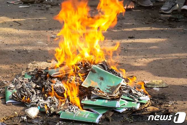 1일(현지시간) 군사 쿠데타를 반대하는 시위가 계속되는 미얀마 양곤에서 시민들이 2008년 헌법 책자를 불태우고 있다. © AFP=뉴스1 © News1 우동명 기자