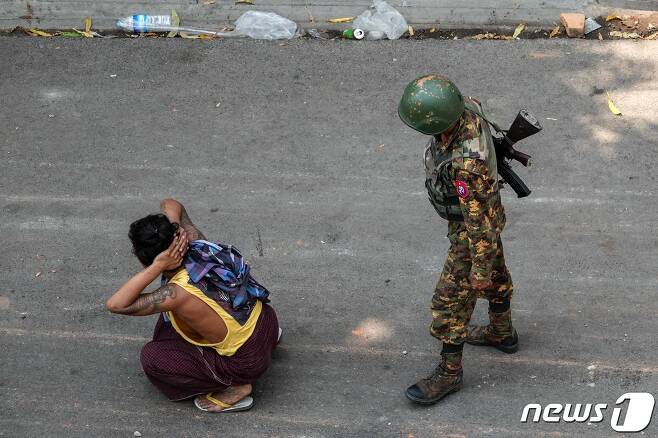3일(현지시간) 미얀마 만달레이에서 한 무장한 군인이 시민을 무릎꿇린 채 감시하고 있다. © AFP=뉴스1 © News1 이동원 기자
