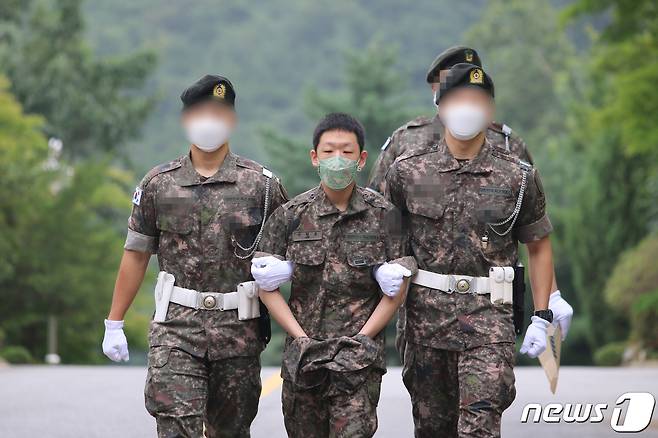 텔레그램에서 성 착취물을 제작·유포한 혐의 등으로 구속기소된 '박사방' 공동운영자 이원호(가운데)가 작년 8월7일 육군 수도방위사령부 보통군사법원에서 열린 1차 공판에 출석하고 있다. (육군 제공) 2020.8.7/뉴스1