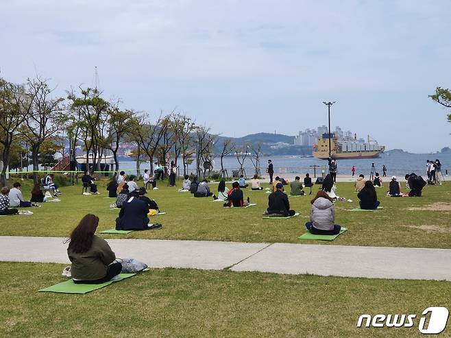 국립해양박물관 앞 정원에서 '海(해)멍海(해)몽 행사 참가자들이 앉아 바다를 보며 명상을 하고 있다.2021.4.21 /© 뉴스1 손연우 기자