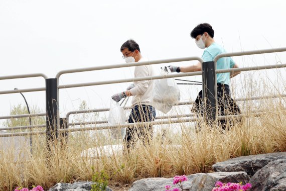 나경수 SK종합화학 사장(왼쪽)이 한강시민공원에서 회사 구성원들과 쓰레기를 줍고 있다. SK종합화학 제공