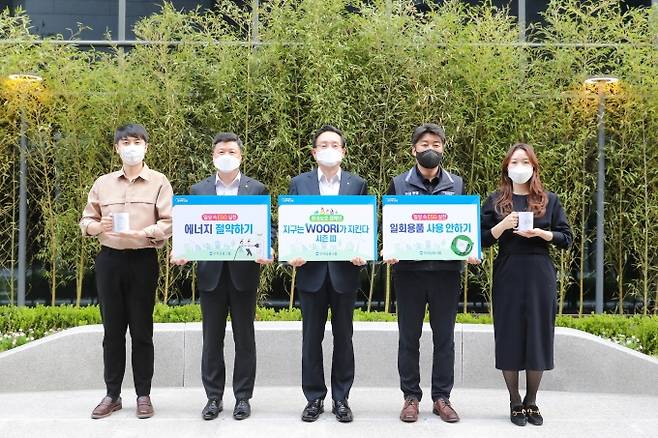 우리금융그룹은 서울시 중구 소재 우리금융그룹 본사 '우리숨터'에서 '지구는 WOORI가 지킨다' 시즌Ⅲ 환경보호 캠페인 행사를 진행했다. 손태승(가운데) 우리금융그룹 회장, 권광석(왼쪽 두번째) 우리은행장, 박필준(왼쪽 네번째) 노동조합위원장이 기념촬영을 하고 있다. [사진=우리금융그룹]