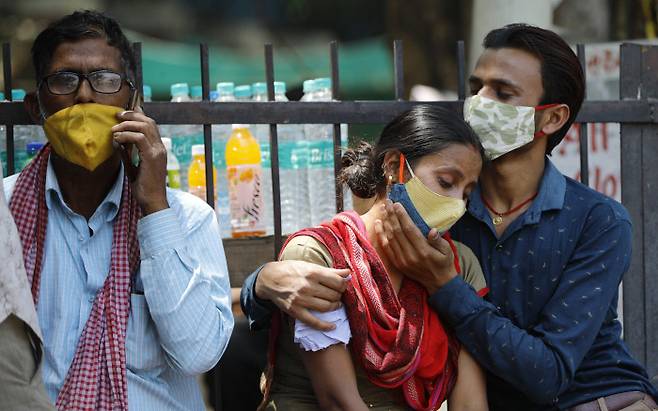 인도 뉴델리의 한 병원 앞에서 코로나19로 가족을 잃은 사람들이 슬픈 표정으로 앉아있다. 뉴델리|AP연합뉴스