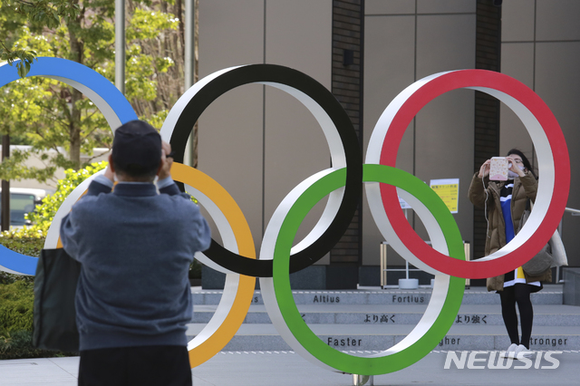 [도쿄=AP/뉴시스]지난달 17일 일본 도쿄에 설치된 올림픽 오륜 조형물을 시민들이 촬영하고 있다. 2021.04.06.