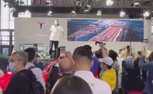 지난 19일 상하이 모터쇼 테슬라 전시장 차량 지붕에서 한 소비자가 기습시위를 벌였다./중국 웨이보 캡처