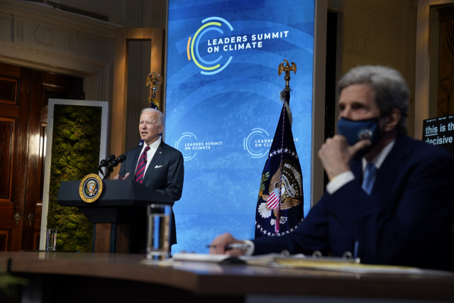 22일(현지 시간) 조 바이든(왼쪽) 미국 대통령이 존 케리 기후특사가 지켜보는 가운데 한국과 중국 등 40개국 정상이 참여한 기후정상회의에서 연설하고 있다. /AP연합뉴스
