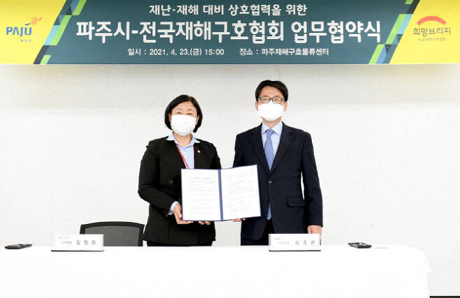 최종환 시장(오른쪽)과 김정희 사무총장이 협약서를 들어보이고 있다.(사진=파주시 제공)
