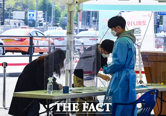 국내에서 신종 코로나바이러스 감염증(코로나19) 자가검사키트 2종이 허가를 획득했다. 19일 오전 서울 중구 서울역 광장에 마련된 선별진료소에서 시민들이 검사 전 문진표를 작성하고 있다. /이동률 기자