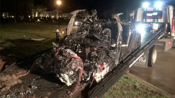 지난 17일(현지시간) 미국 텍사스주 휴스턴 인근에서 충돌후 불에 탄 테슬라 차량의 잔해가 견인되고있다.로이터뉴스1