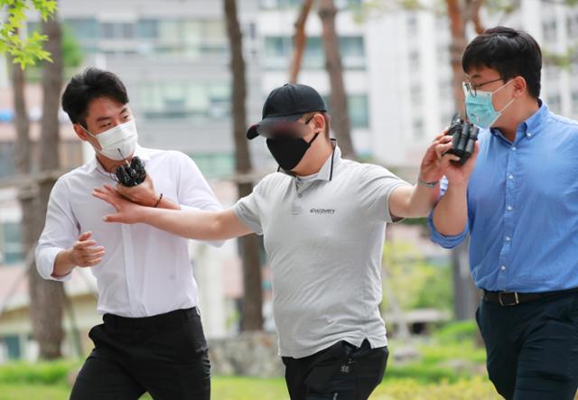 응급환자가 타고 있던 구급차를 막아서 환자를 사망에 이르게 한 혐의를 받는 택시기사 최모씨가 지난해 서울동부지법에서 열린 영장실질심사에 출석하며 질문하는 취재진을 밀치고 있다. 뉴스1