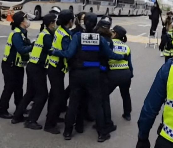 지난 24일 온라인 커뮤니티에 '오늘자 K-여경'이라는 제목으로 여성 시위자 1명을 여경 9명이 제압하고 있는 장면이 담긴 영상이 올라왔다. [사진제공=온라인 커뮤니티]