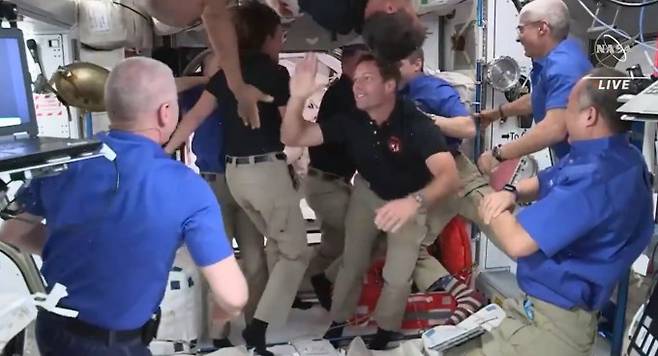 24일 오후(한국시간) 국제우주정거장(ISS)에 도착한 우주인 4명을 ISS에 체류중이던 우주인들이 반갑게 맞이하고 있다. 파란색 옷을 입은 이들이 기존 우주인들이며 검정색 옷을 입은 우주인들은 이번에 ISS에 도착한 우주인들이다. NASA 제공.