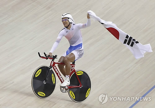 2010년 11월 광저우 아시안게임 사이클 경기에 참가한 장선재 선수가 프리미엄 자전거 '써벨로'를 타고 첫 번째로 결승점을 통과한 뒤 태극기를 흔들며 트랙을 돌고 있다. <연합뉴스>