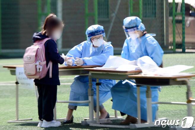 지난 19일 오전 광주 광산구 한 초등학교에서 학생 2명이 신종 코로나바이러스 감염증(코로나19)에 확진된 가운데 해당 학교 한 학생이 진단 검사를 받고 있다./사진제공=뉴스1