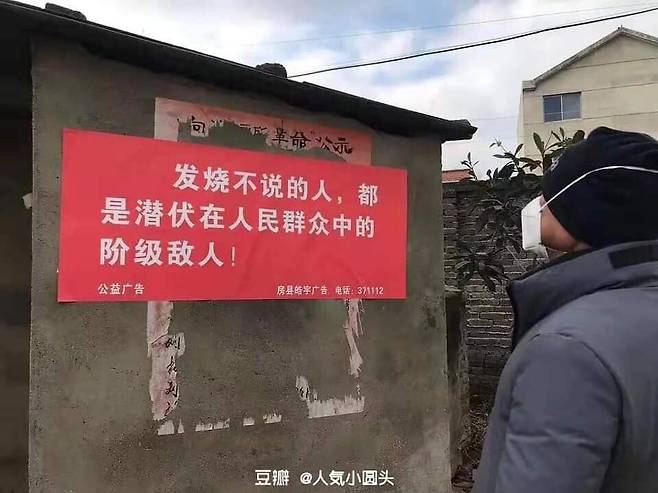 A Chinese man looks at a public announcement poster that reads, "Those who don't share the fact that they have a fever are enemies of the people." (provided by Cum Libro)