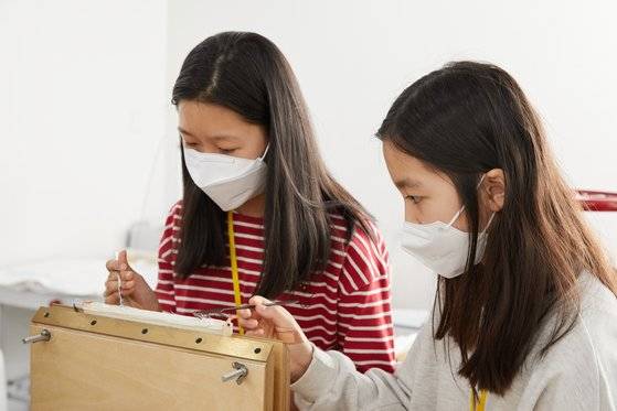 소중 학생기자단이 스페튤라로 접착제를 발라주고 긁어내주는 책등 클리닝 과정을 체험하고 있다. 이 과정에서 책의 헤드밴드 머리띠에서 나온 종이들(아래 사진). 재영은 수선 중에 나온 책의 흔적들을 보관한다고 말했다.