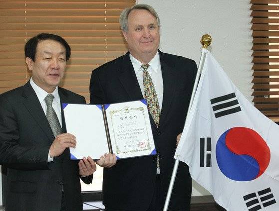 지난 2012년 권재진 법무장관이 21일 오후 과천 법무부청사에서 인요한 연세대 의대 교수에게 대한민국 국적증서를 수여한뒤 함께 포즈를 취하고 있다. 인요한 교수는 공로로 국적을 취득한 최초의 특별귀화자다. 연합뉴스