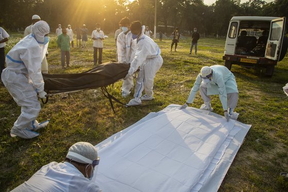 인도 구와하티에서 신종 코로나바이러스 감염증으로 사망한 이들의 시신을 묻고 있는 모습. AP=연합뉴스