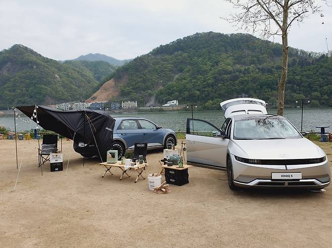 Two models of the Ioniq 5 are displayed in car camping settings in Namyangju, Gyeonggi Province. (Bae Hyun-jung/The Korea Herald)