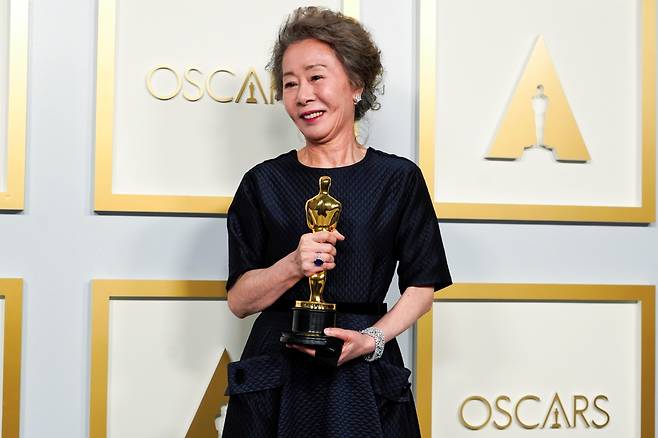 Youn Yuh-jung poses for photos after winning the best supporting actress award at 93rd Academy Awards in Los Angeles, on Sunday. (Reuters-Yonhap)