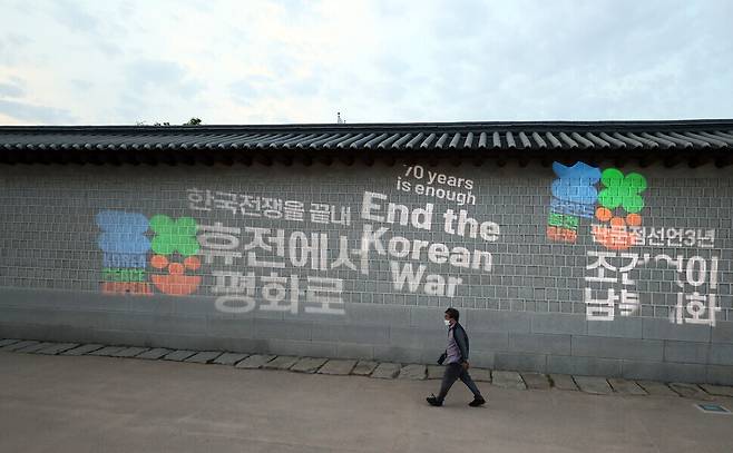 A light projection performance held Monday in Seoul by peace activists shows messages reading “end the Korean War,” “70 years is enough” and “unconditional inter-Korean dialogue.” (Yonhap News)