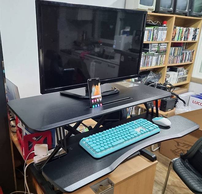 루나랩 전동 스탠딩 책상에 32인치 모니터와 스마트폰을 설치한 모습