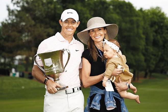 10일 PGA 투어 웰스파고 챔피언십 우승 트로피를 든 로리 매킬로이(왼쪽부터)와 아내 에리카, 딸 포피. /AFP 연합뉴스