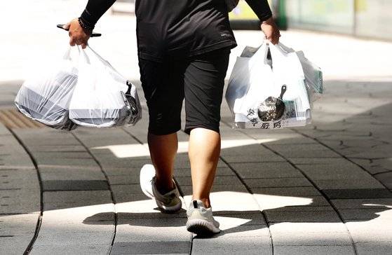 신종 코로나바이러스 감염증(코로나19) 재확산으로 포장·배달 음식이 늘어난 지난해 8월25일 서울 시내에서 배달원이 포장된 음식을 배달하고 있다.연합뉴스